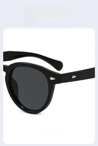 Detail shot of vintage round black sunglasses featuring silver diamond-shaped rivets