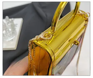 Detailed close-up of premium gold metallic handbag with curved handle and fine chain strap