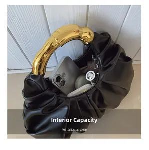 Makroaufnahme der Innenkapazität der schwarzen Falten-Tasche mit goldenem Griff