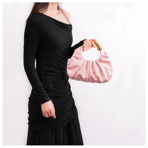 Detail der hellrosa gerafften Cloud-Tasche mit elegantem Goldringgriff von Model gehalten