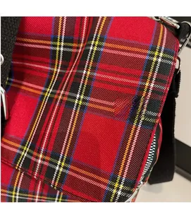Close-up of red plaid fabric texture on punk style tote bag with silver metal buckle