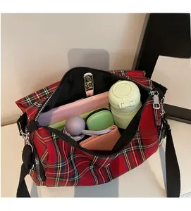 Interior view of red plaid shoulder bag showing large capacity for umbrella and bottle