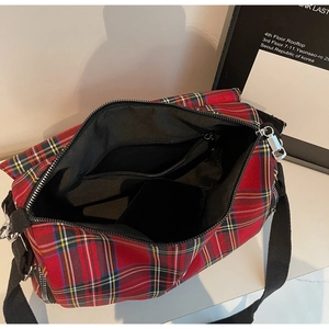 Macro shot of red plaid crossbody bag showing internal zipper pocket and silver zipper detail