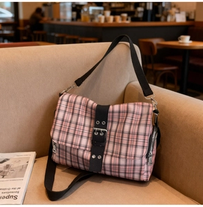 Detailed macro view of pink and black plaid canvas bag with metallic zipper and nylon strap