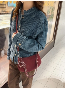 Detail view of burgundy crescent bag with silver heart studs and slim shoulder strap