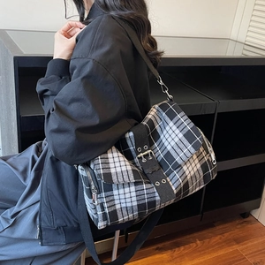 Classic black and white checkered messenger bag with wide strap and metallic buckles