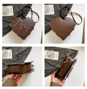 Detailed macro view of heart-shaped gothic bag with spider embroidery and rhinestone detail