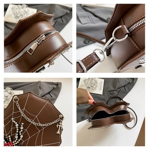 Detail of gothic dark heart handbag featuring white spider web stitching and silver cross