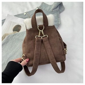 Détail du mini sac à dos en faux daim marron avec garniture en fourrure synthétique blanche