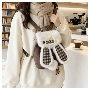 Détail d'un sac à dos lapin en peluche avec oreilles à carreaux et logo Happy Days