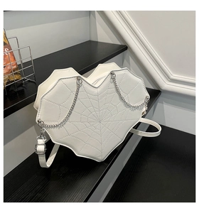 Detail of white heart-shaped crossbody bag with stitched spider web pattern and chain