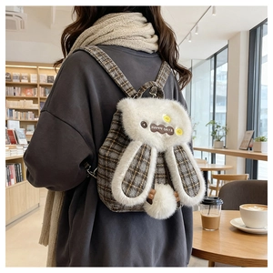 Détail d'un sac à dos à carreaux avec oreilles de lapin et broderie Happy Days