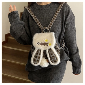 Gros plan du sac à dos lapin en peluche avec tissu à carreaux et écusson Happy Days