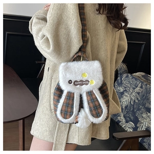 Détail d'un sac à dos en peluche forme lapin avec motif à carreaux brun et patch brodé