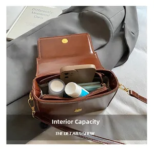 Detail view of the spacious inner compartment of the brown vintage square leather bag