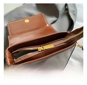 Detail view of the brown leather bag interior with golden zipper and magnetic buckle