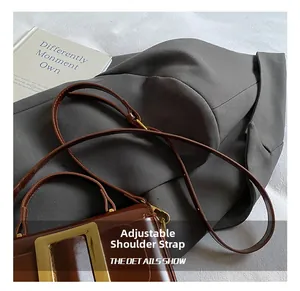 Detail showing the adjustable leather shoulder strap of a brown vintage square bag