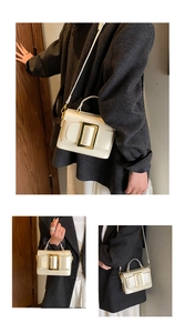 Détail du sac bandoulière blanc avec boucle dorée et bandoulière amovible en cuir