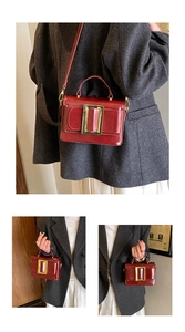 Détail macro du sac à main en cuir verni bordeaux avec boucle en métal doré élégante