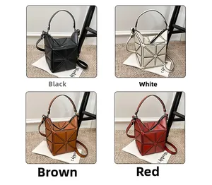 Detail of geometric patchwork bucket bag in black white brown and red colors