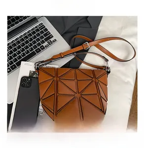 Brown geometric bucket bag showing size comparison with a smartphone and textures