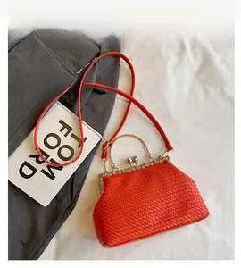 Detailed view of orange woven texture and vintage metal clasp with pearl decoration