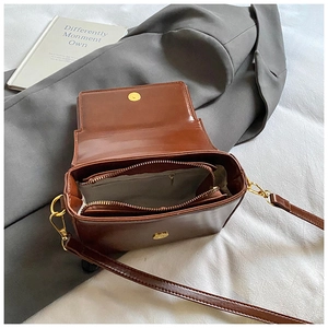 Vue détaillée de l'intérieur du sac à bandoulière marron avec poche zippée et rabat