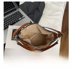 Macro view of the large interior compartment of this brown leather bucket bag