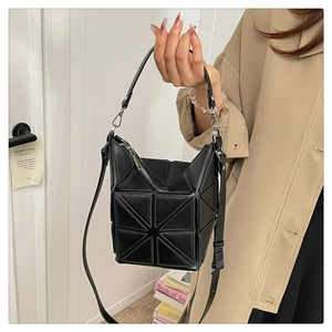 Detailed shot of a black geometric bucket bag with 3D triangular folding texture and silver zip