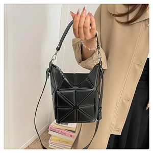 Detail of black geometric bucket bag showing textured stitching and silver hardware