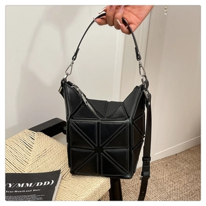 Detail view of black geometric star pattern bucket bag with silver metal zippers
