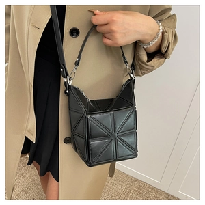 Detail of geometric patchwork bucket bag with silver zipper and matte black finish