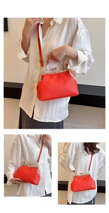 Detail of red woven evening bag with gold rhinestone clasp and leather shoulder strap