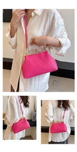 Detail of rose red woven evening bag with gold metal frame and spherical clasp