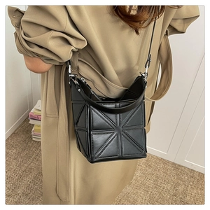 Detail shot of the geometric bucket bag featuring 3D triangle panels and adjustable strap