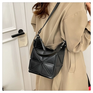 Detail of black geometric bucket bag showing 3D triangle panels and smooth PU leather