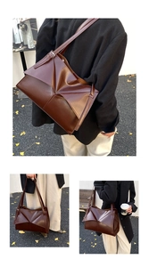 Dettaglio macro della borsa tote in pelle marrone con design a pieghe e finitura lucida