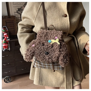 Dettaglio dello zaino in peluche a forma di cane con texture in pile e base a scacchi