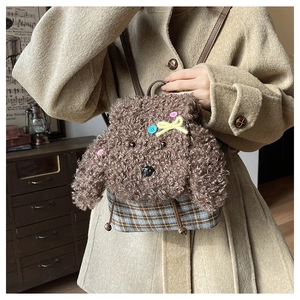 Dettaglio dello zaino in peluche a cucciolo con trama in lana di agnello e quadri vintage
