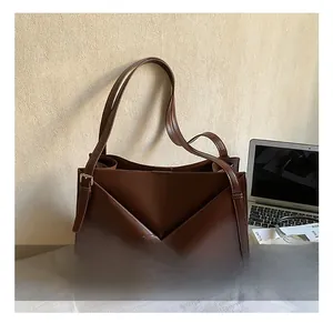 Dettaglio borsa tote marrone caffè con pieghe geometriche e fibbia argentata regolabile