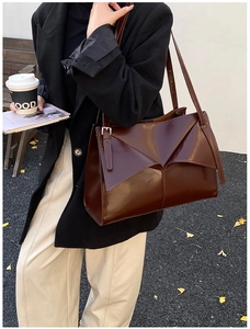 Dettaglio borsa tote bordeaux con patta geometrica e tracolla con fibbia argentata