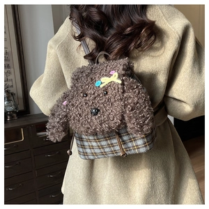 Dettaglio di un mini zaino in peluche a forma di cane con tessuto scozzese indossato