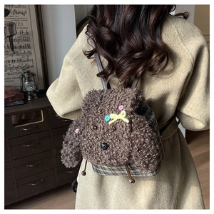 Dettaglio dello zaino a forma di cucciolo di peluche marrone con tessuto scozzese grigio