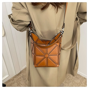 Close-up of brown geometric patchwork bucket bag showing textured triangular leather patterns