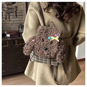 Dettaglio dello zaino a forma di cucciolo marrone con bottoni colorati e base a quadri