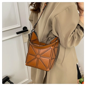 Detailed close-up of brown geometric bucket bag showing 3D triangle panels and adjustable strap