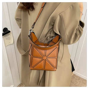 Macro shot of geometric stitching details and caramel bucket bag texture with silver hardware