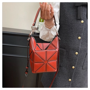 Detail of red geometric panel bucket bag with silver hardware and chic fold design