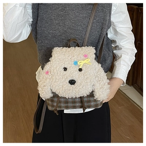 Dettaglio dello zaino a cucciolo in peluche con motivi a scacchi e fiocco rosa