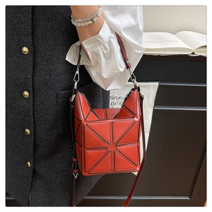 Detail view of red geometric bucket bag with matte triangular tiles and silver hardware